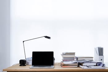 Tablet on desk with stack of books