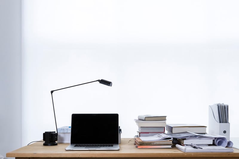 Tablet on desk with stack of books