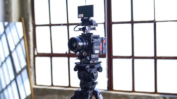 Camera on tripod for creating videos of portfolio managers