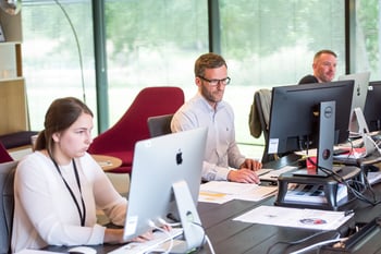 Business professionals working on desktop monitors