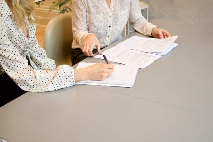 two women in a meeting looking over paperwork