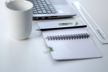 planner, pen, mug, and laptop on desk